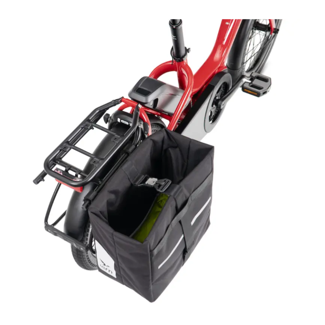 A black Tern Cargo Hold Pannier attached to the rear rack of a red Tern NBD electric bicycle, shown against a plain white background.