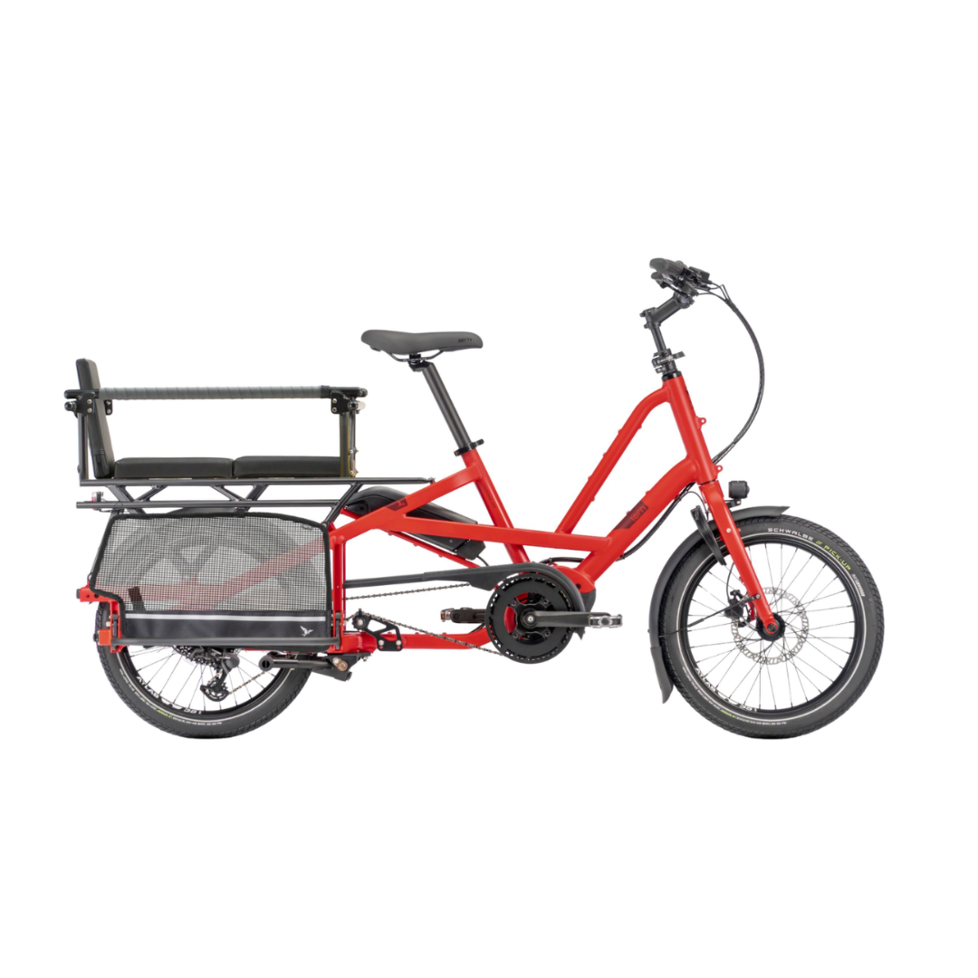 A red Tern Quick Haul Long cargo bicycle with a rear cargo basket, black seat, and black handlebars, shown from a side profile on a solid white background.